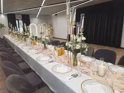 Elegancko udekorowany stół na przyjęcie z kwiatami i świecami.
