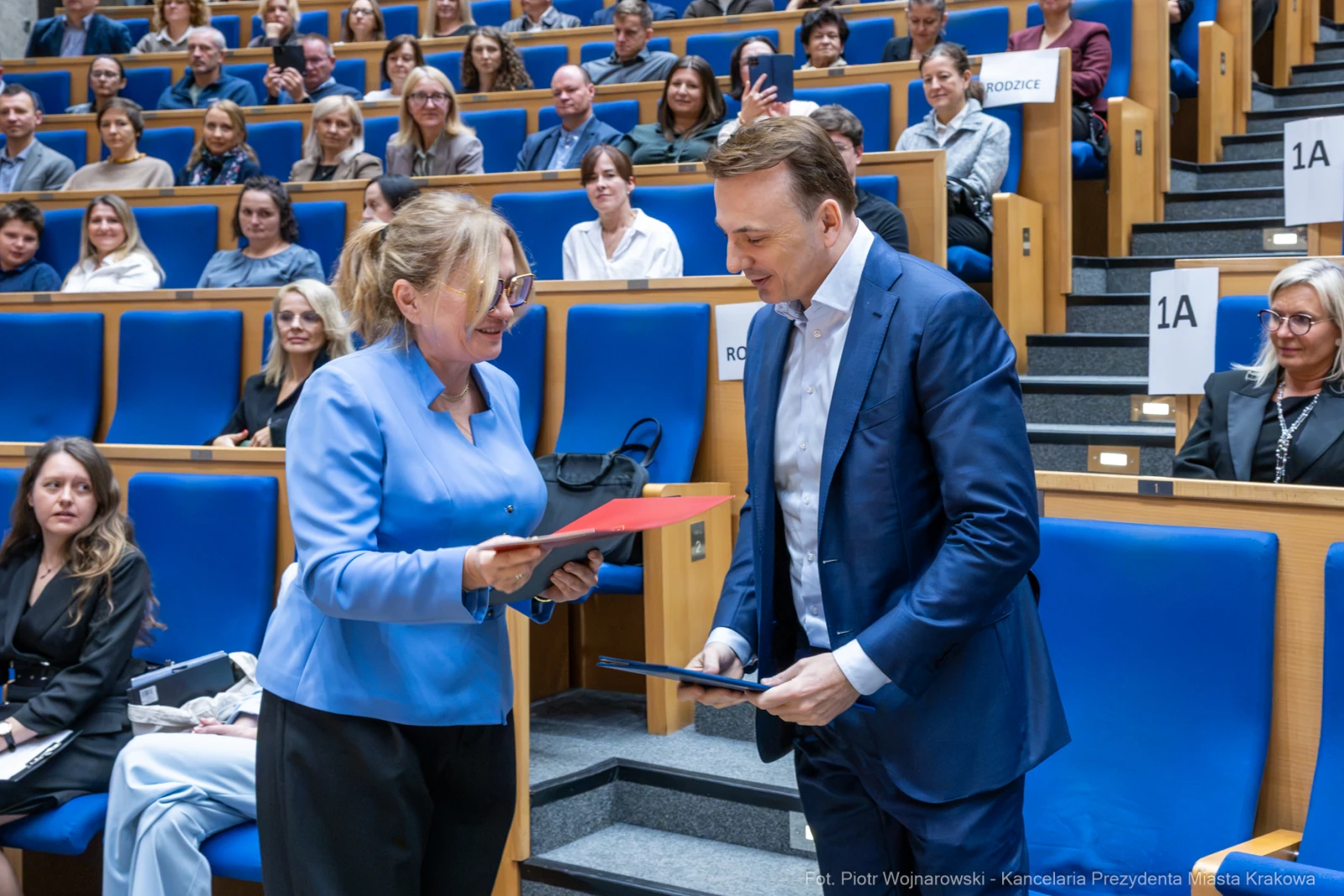 Wręczenie dokumentów podczas uroczystości w sali konferencyjnej.  Autor: Piotr Wojnarowski