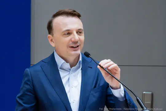 Mężczyzna w garniturze przemawia do mikrofonu.