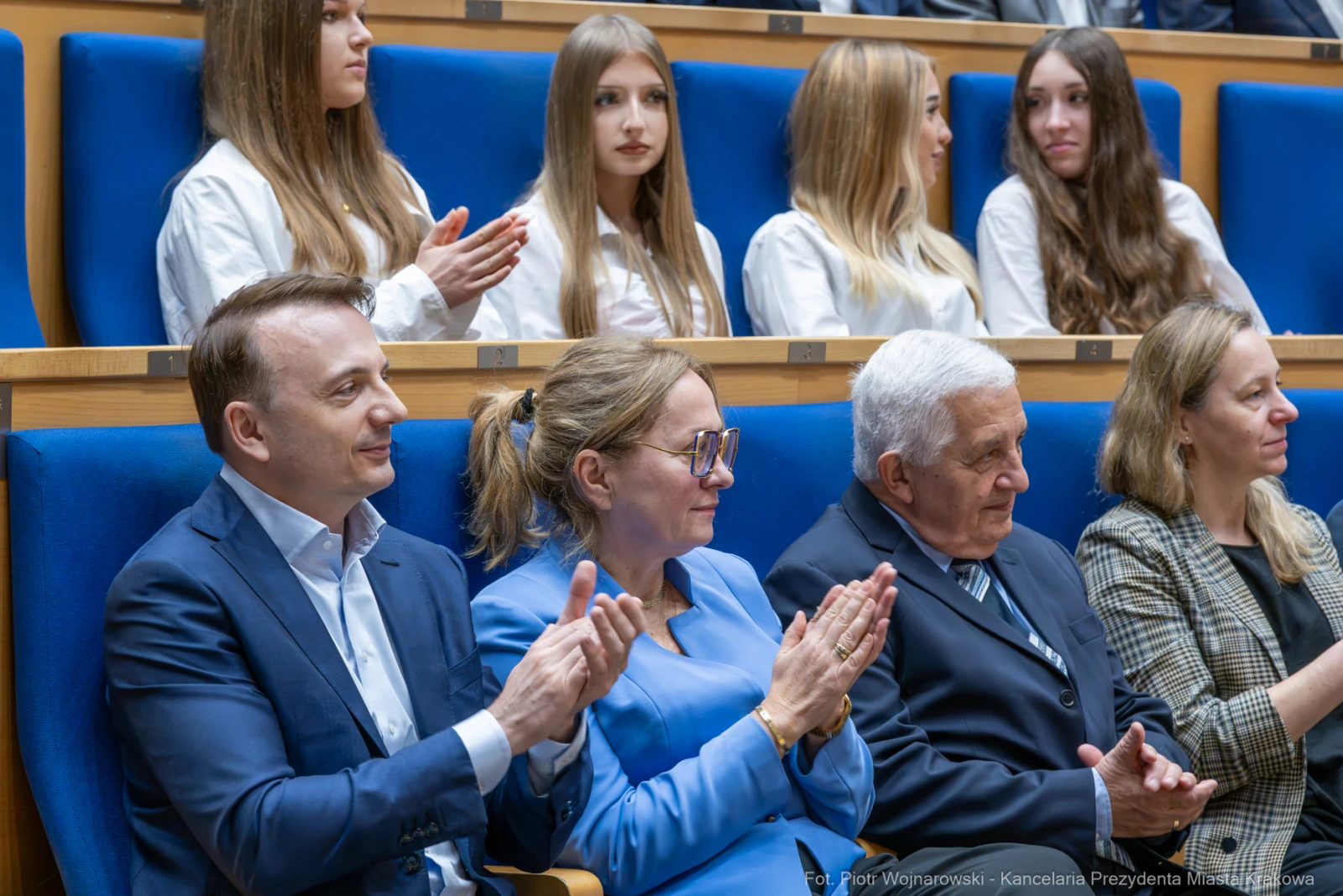 Grupa osób w sali, niektórzy klaskają, inni siedzą w tle.  Autor: Piotr Wojnarowski