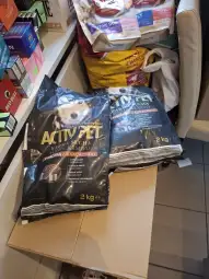 Worki z karmą dla psów ActivPet, 2 kg każdy, leżą na podłodze w pomieszczeniu.