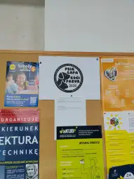 Plakat promujący wydarzenie "Psia Łapa, Kocia Pazura 2026" na tablicy ogłoszeń.