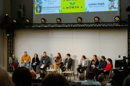 Panel dyskusyjny z uczestnikami na scenie, poruszający temat zrównoważonego rozwoju.