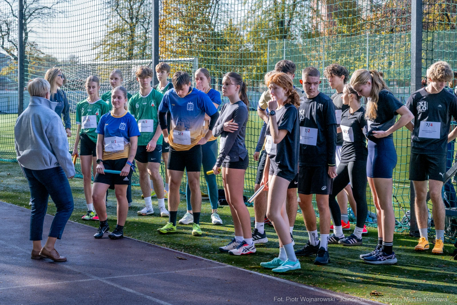 Grupa młodych sportowców przygotowujących się do biegu na boisku.  Autor: Piotr Wojnarowski