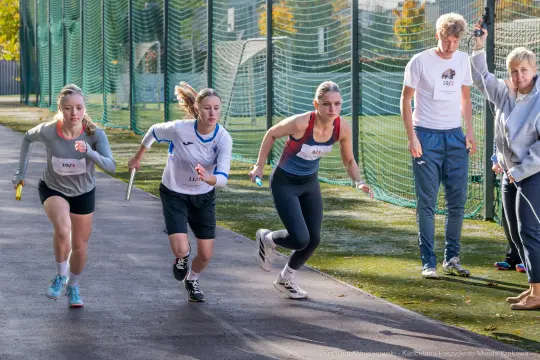 Biegaczki startujące w sztafecie na torze lekkoatletycznym.