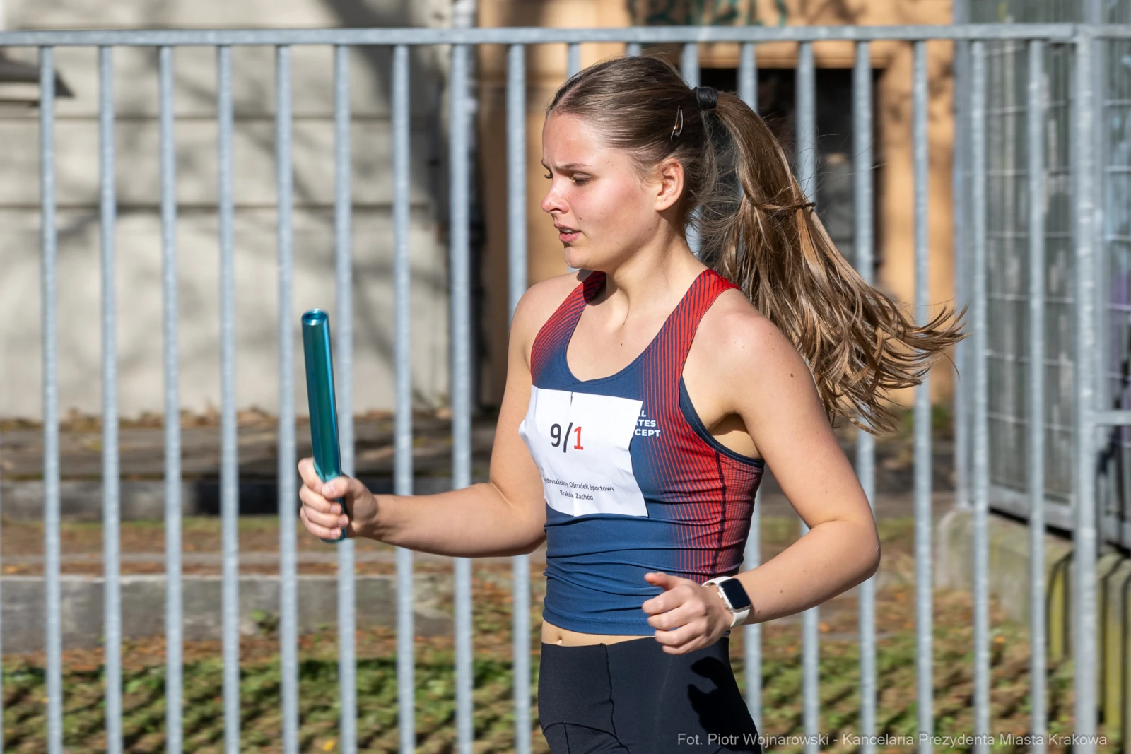 Biegaczka trzymająca pałeczkę sztafetową, w trakcie zawodów lekkoatletycznych.  Autor: Piotr Wojnarowski