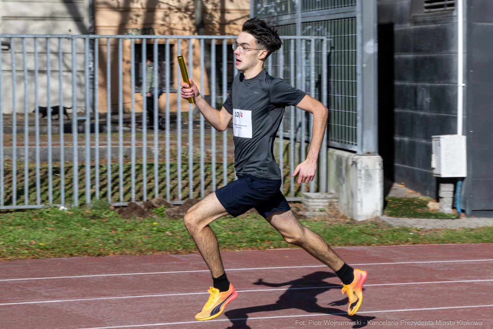 Młody mężczyzna biegnący z pałeczką w ręku na torze lekkoatletycznym.  Autor: Piotr Wojnarowski
