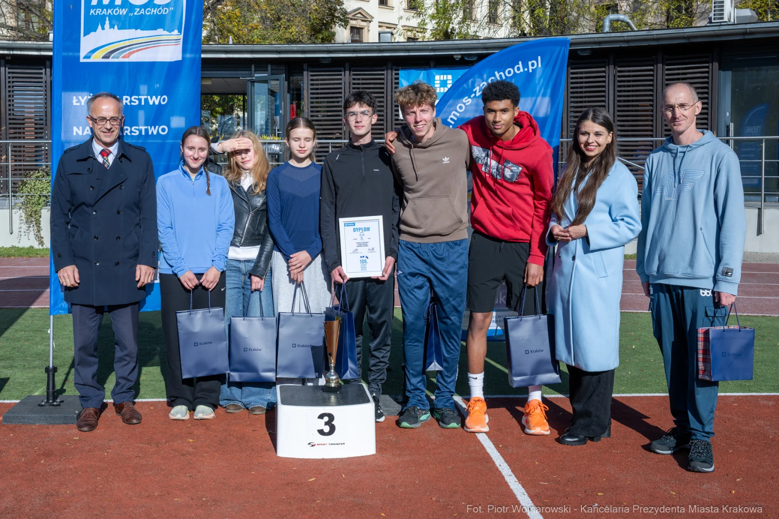 Uczestnicy zawodów sportowych z nagrodami na podium.  Autor: Piotr Wojnarowski