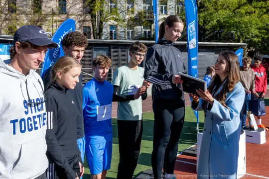 Młodzież odbierająca nagrody na zawodach sportowych.