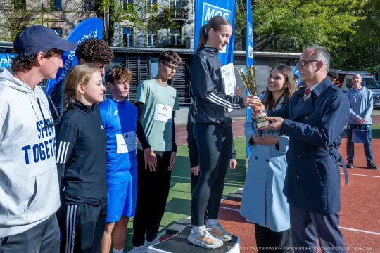 Młodzież odbierająca trofeum podczas zawodów sportowych.