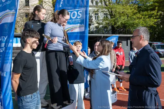 Uczestnicy zawodów sportowych na podium, wręczenie nagród przez organizatorów.