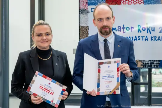 Wręczenie nagrody Animatora Roku 2023 w Krakowie. Dwie osoby z dyplomami i nagrodą pieniężną.