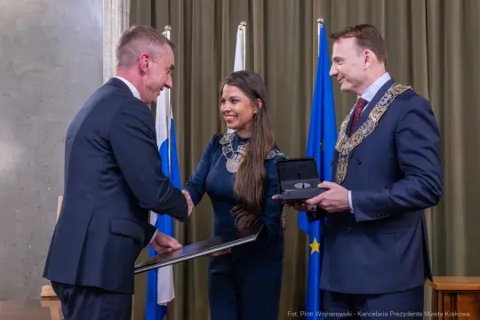 Uroczystość wręczenia nagród z udziałem przedstawicieli władz i flagami.