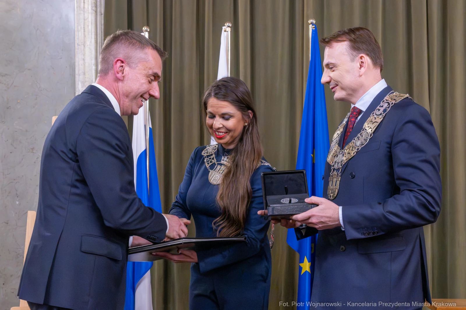 Ceremonia wręczenia odznaczeń w obecności flag i przedstawicieli władz.  Autor: Piotr Wojnarowski