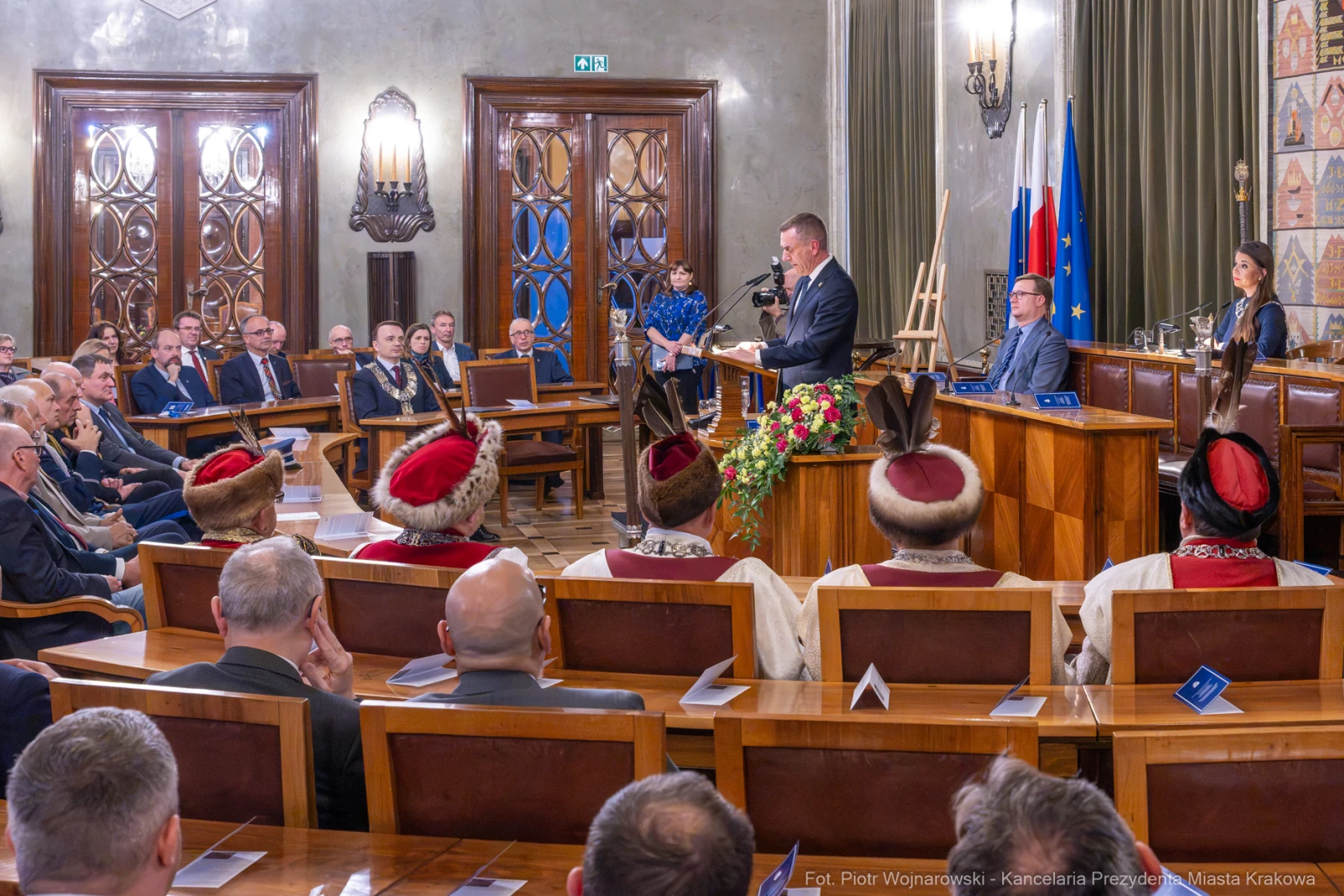 Uroczystość w sali obrad z mówcą i uczestnikami w tradycyjnych strojach.  Autor: Piotr Wojnarowski