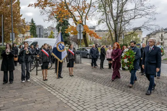 Uroczystość złożenia kwiatów, obecność pocztu sztandarowego i muzyków.