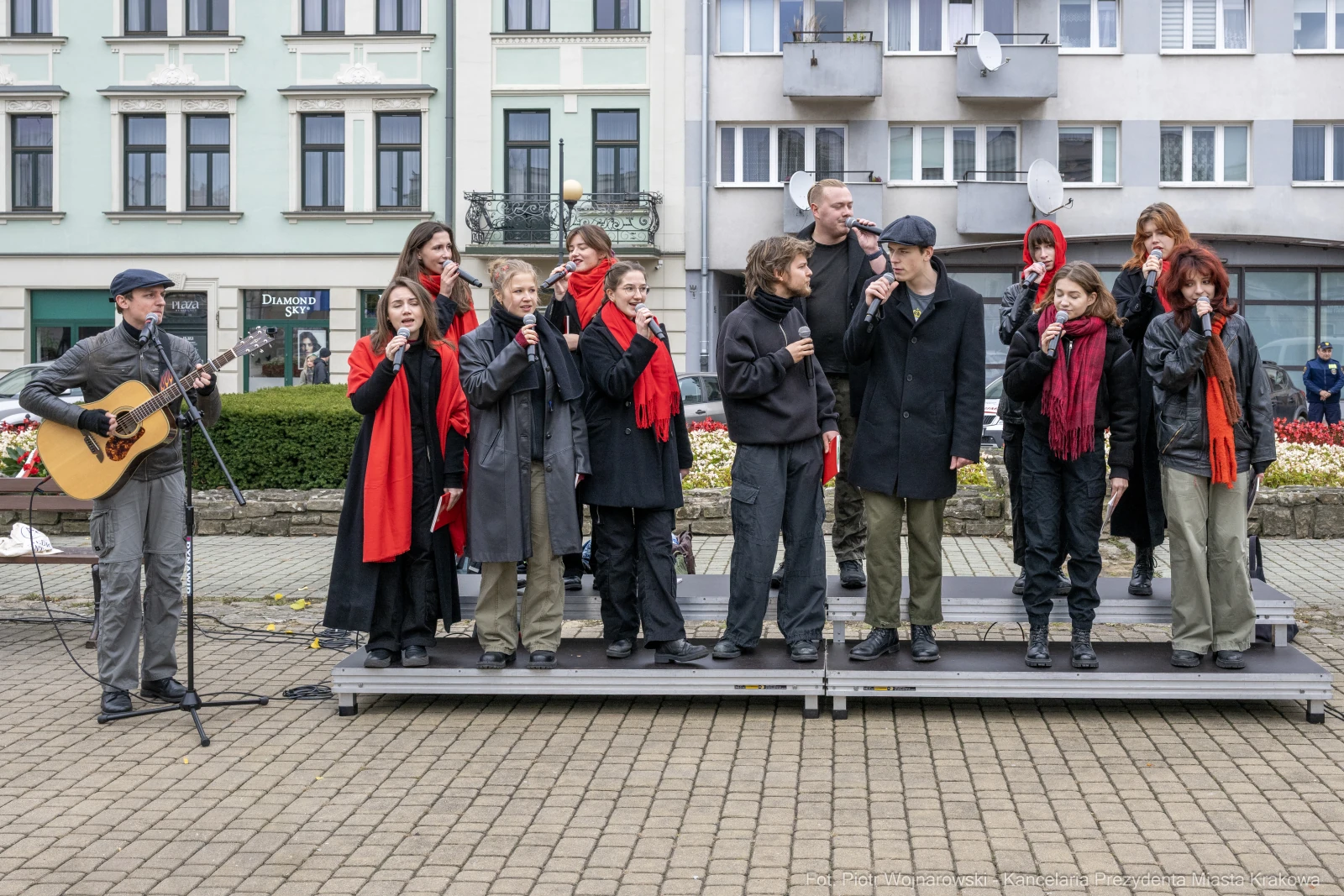 Grupa wykonawców śpiewa na scenie, część z nich trzyma mikrofony, a jeden gra na gitarze.  Autor: Piotr Wojnarowski