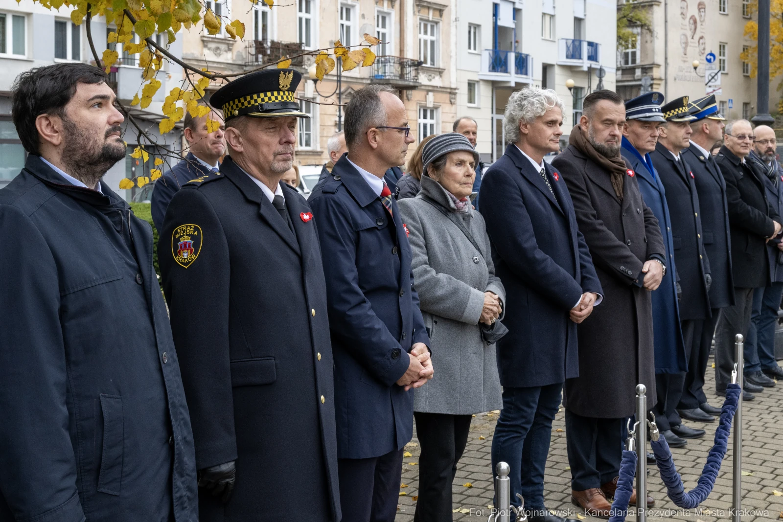 Uczestnicy ceremonii rocznicowej w strojach formalnych, z symbolami narodowymi.  Autor: Piotr Wojnarowski