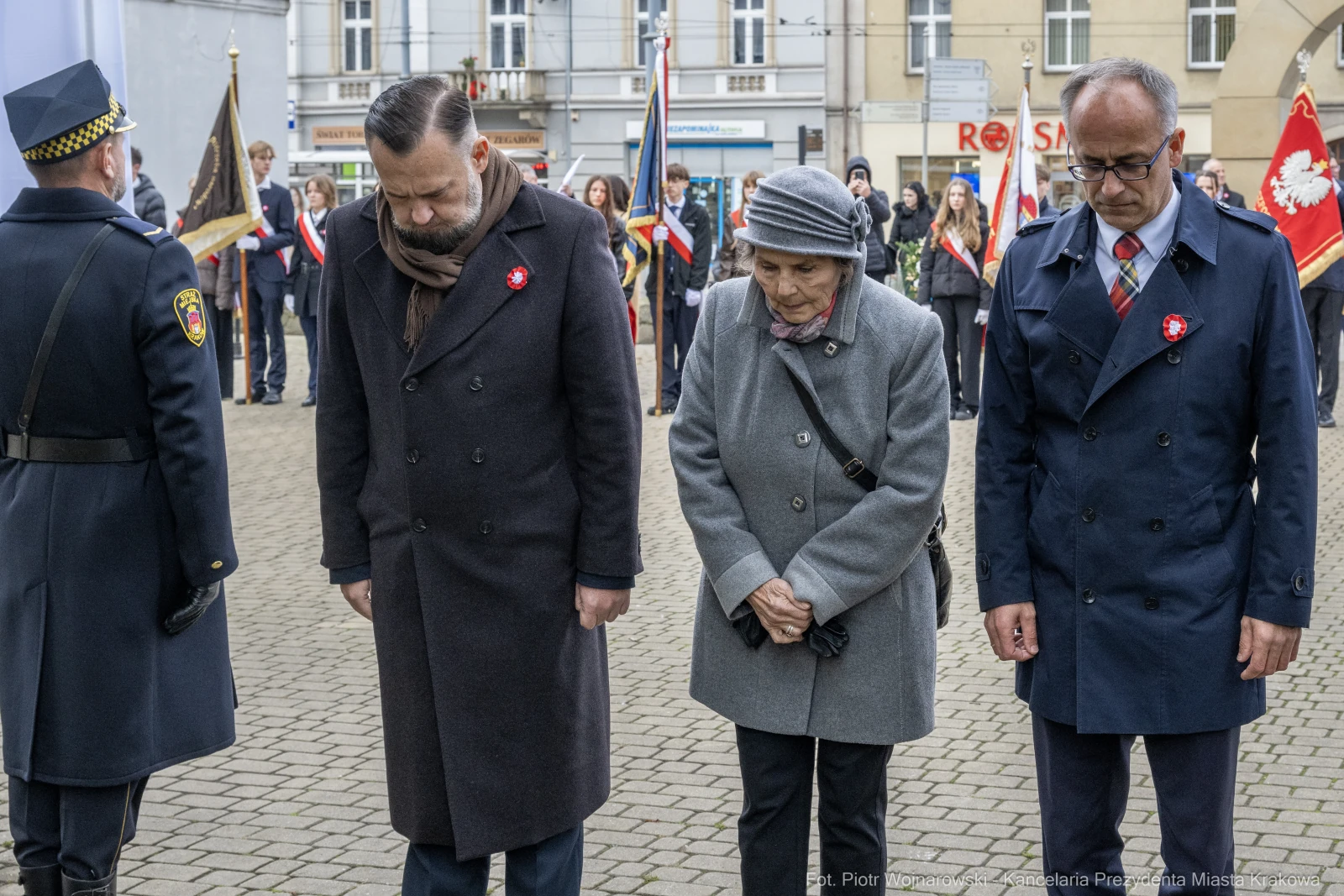 Trzy osoby w eleganckich ubraniach składają hołd, stojąc w milczeniu na uroczystości.  Autor: Piotr Wojnarowski