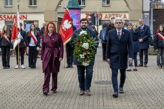 Ceremonia złożenia wieńca z okazji święta narodowego, uczestnicy w galowych strojach.