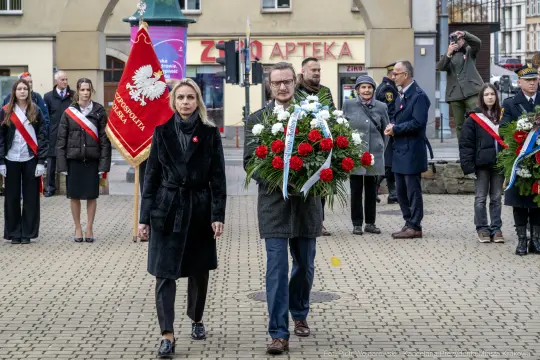 Obchody złożenia kwiatów z okazji święta narodowego, uczestnicy w strojach galowych.