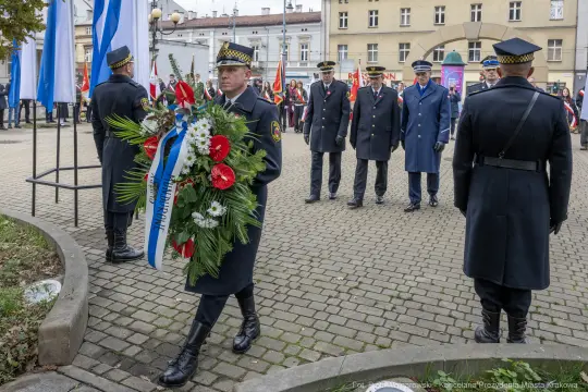 Uroczystość złożenia wieńca przez funkcjonariuszy w mundurach.