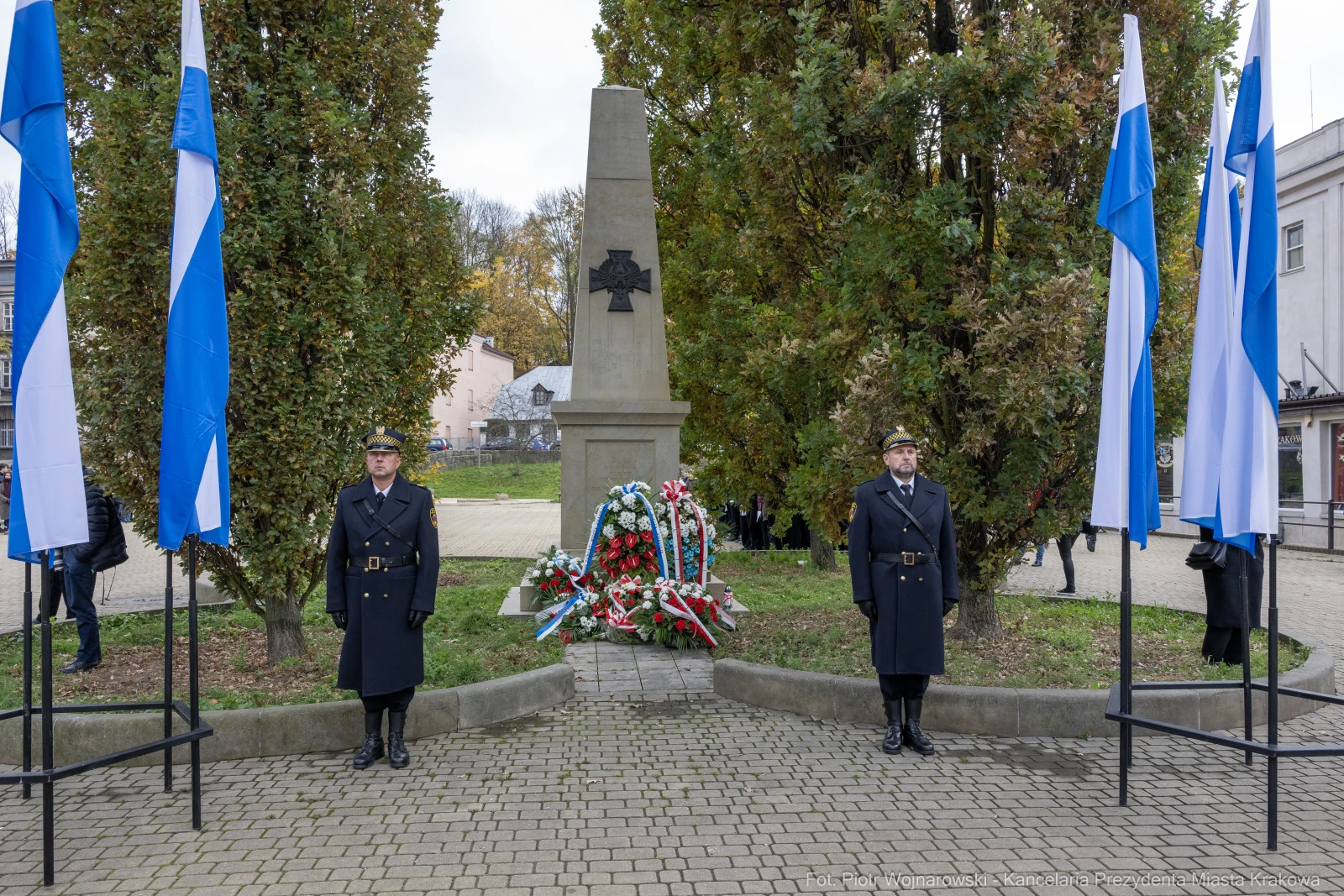 Pomnik z flagami i wartą honorową, złożone kwiaty w hołdzie.  Autor: Piotr Wojnarowski