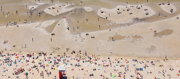 Plaża w Estonii - widok z góry na piaszczystą plażę i bardzo płytkie morze, ludzie opalają się i wchodzą w morze
