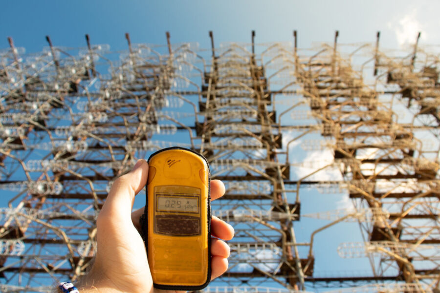 Mierzenie poziomu napromieniowania w Czarnobylu - na pierwszym planie licznik gaigera, dalej industrialne tło