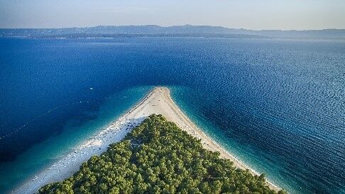Plaża Zlatni Rat na wyspie Brač z lotu ptaka. Trójkątna piaszczysta plaża na wyspie. 