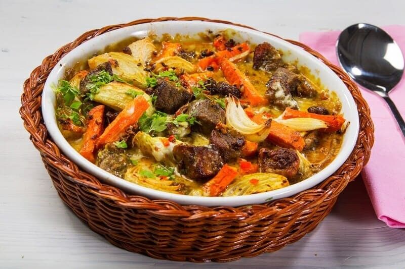 Tradycyjna potrawa fińska zupa z mięsem renifera. Stojący na stole głęboki talerz z potrawą z warzywami oraz kawałkami ciemnego mięsa.