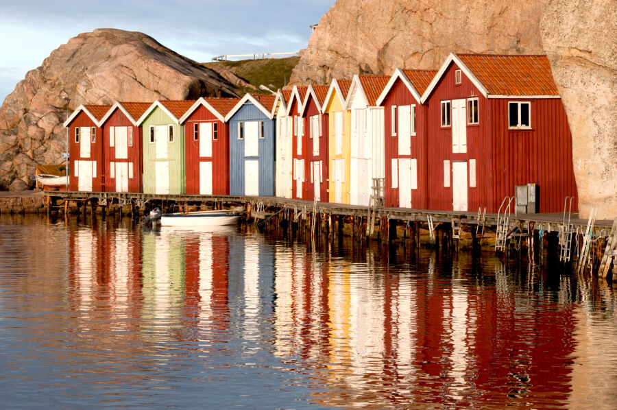 Chaty rybackie na wybrzeżu. Bardzo kolorowe małe domki stojące nas wodą na skalistym wybrzeżu. 