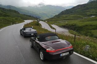 samochody marki Porsche na krętej asfaltowej drodze w górach. Fot. Stowarzyszenie Pasja Porsche