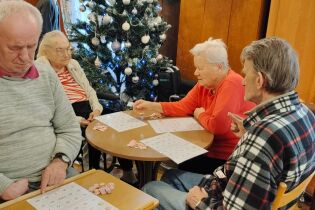 Pizza i BINGO! Na zdjęciu osoby skupione na grze w BINGO!