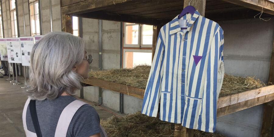 Replika obozowego pasiaka z fioletowym trójkątem na wystawie w Tel Avivie w Izraelu 
