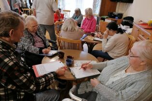 Dzień zagadek, quizów i łamigłówek Na zdjęciu Mieszkańcy DPS rozwiązujący łamigłówki.
