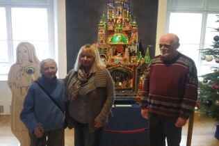 Senior w muzeum odsłona trzecia Osoby zwiedzające na tle szopki krakowskiej w sali muzeum