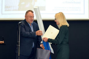 Zastępca Prezydenta Miasta Krakowa Andrzej Kulig wręcza upominek jubileuszowy Dyrektorowi Domu
