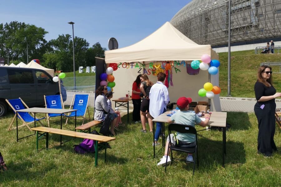 Rodziny uczestniczące w zabawach plenerowych, częściowo odbywających się w namiocie. 