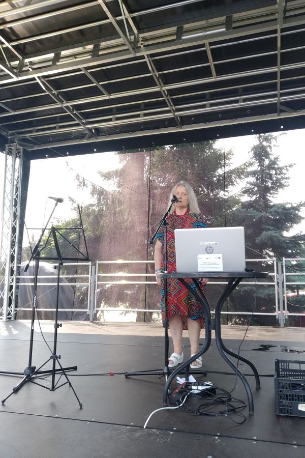 Kobieta występująca na scenie plenerowej.