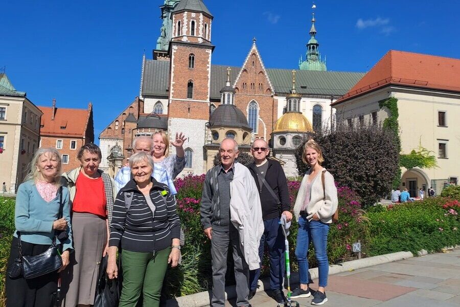 Uczestnicy na tle kwiatów i katedry