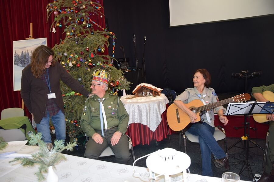 Instruktor terapii oraz uśmiechnięta dwójka harcerzy, z których jeden z koroną otrzymaną na pamiątkę spotkania.