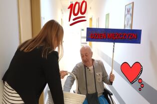 Dzień Mężczyzn kobieta trzymająca duży biały koszyk częstuje mężczyznę siedzącego na wózku słodyczami.