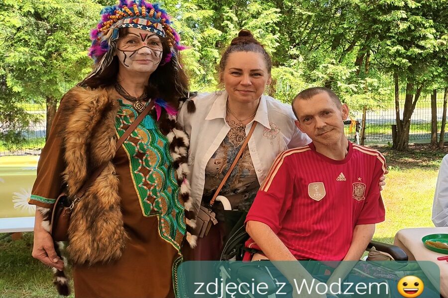 Trzy osoby stoją obok siebie. jedna z nich przebrana jest za indiańskiego wodza