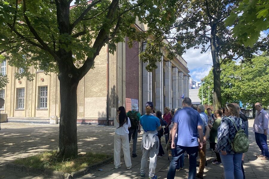 Uczestnicy słuchający historii Muzeum Nowej Huty.