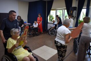 Kilkoro mieszkańców i pracowników chodzi dookoła świetlicy.


