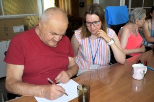 Mieszkaniec rozwiązuje zadanie obok siedzi studentka.