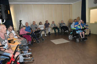 Koło historyczne 02.08.2024 Mieszkańcy zgromadzeni na świetlicy słuchają wykładu prowadzącego.