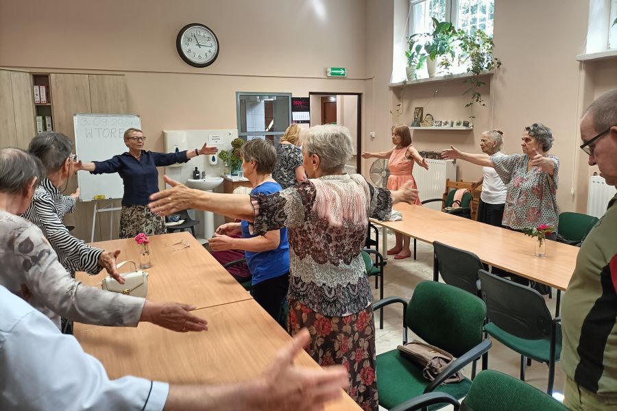 Seniorzy wykonują ćwiczenia oddechowe