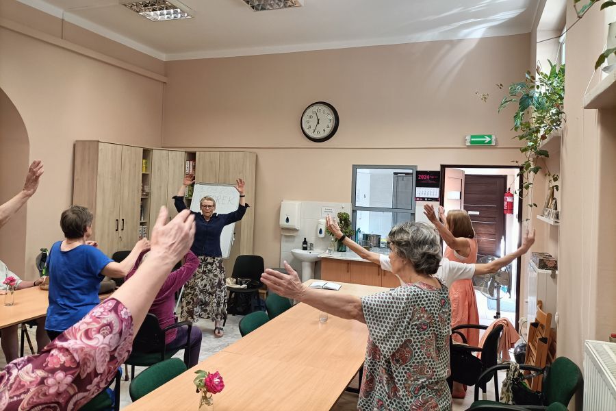 Seniorzy wykonują ćwiczenia ucząc się modulacji głosu oraz foniacji